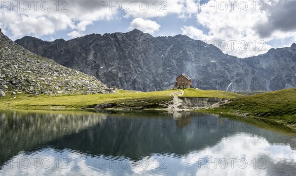 Rocky mountain peaks of the Panargenkamm and mountain hut Neue Reichenberger Hütte, mountain lake Bödensee with reflection, Lasörlinggruppe, Hohe Tauern National Park, East Tyrol, Austria, Europe