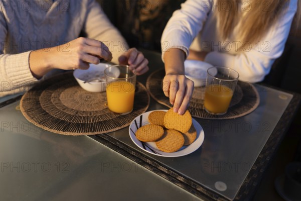Couple having breakfast together, enjoying orange juice and biscuits, starting their day with a shared meal