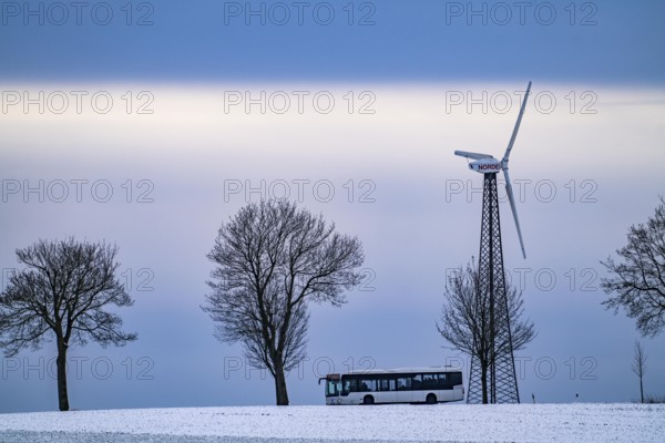 Country road, local train, wind farm, north of Lichtenau, self-proclaimed energy town, over 190 wind turbines and over 1200 solar panels generate 10 times as much electricity as the community of 11, 900 inhabitants consumes, largest onshore cluster of wind turbines in Germany, winter, slightly snow-covered landscape, North Rhine-Westphalia, Germany, Europe