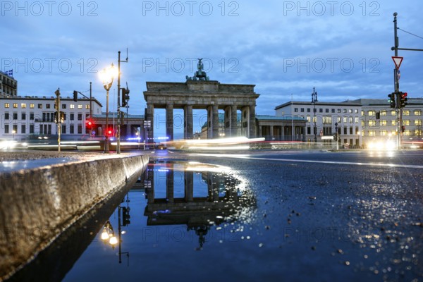 The Brandenburg Tor is reflected in a puddle, cars with lights switched on, Berlin, 27.01.2025, Berlin, Berlin, Germany, Europe