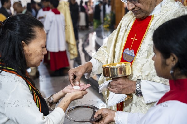 Devotees take holy communion from a priest during a Christmas day sermon on December 25, 2024 in Guwahati, India. Christmas is a festive holiday celebrated on December 25th, marking the birth of Jesus Christ in Christian tradition.