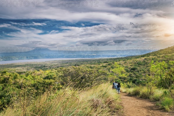 Nature trail overlooking a distant volcano. Landscape of a dirt road overlooking Masaya Lagoon