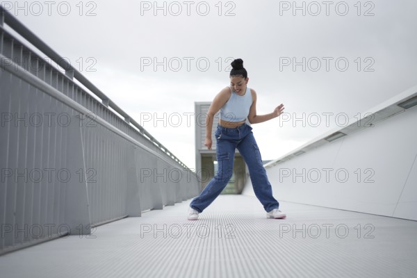 A woman in blue jeans is dancing on a white surface. Concept of freedom and joy as the woman expresses herself through her dance
