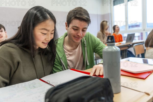 Two high school students are working together on a project in a classroom, demonstrating teamwork and collaboration in education