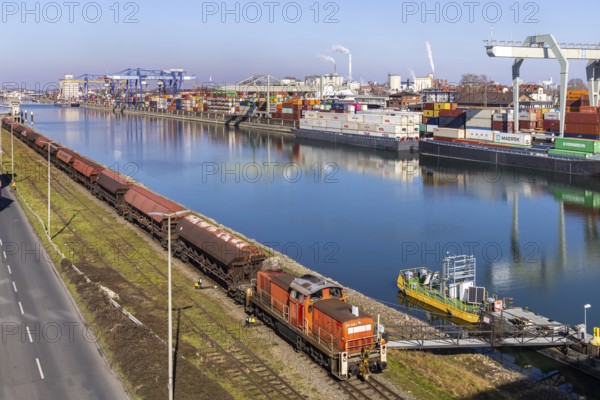 The port of Mannheim is one of Europe's most important inland ports and container terminals. Sea containers are stacked under gantry cranes waiting to be loaded onto lorries and goods trains. Mannheim, Baden-Württemberg, Germany, Europe