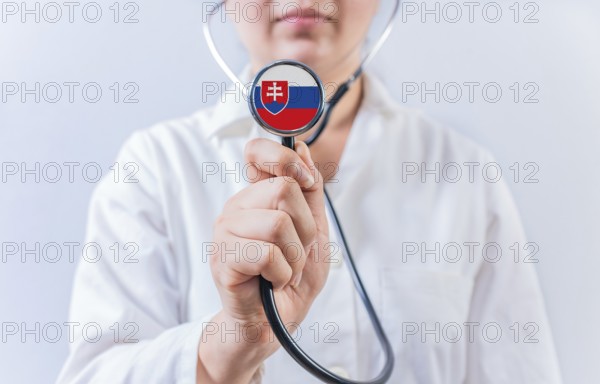 Female doctor holding stethoscope with Slovakian flag. National health system of Slovakia