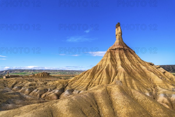 Eroded rock formations create a dramatic landscape in the bardenas reales desert, navarre, spain, under a vibrant blue sky