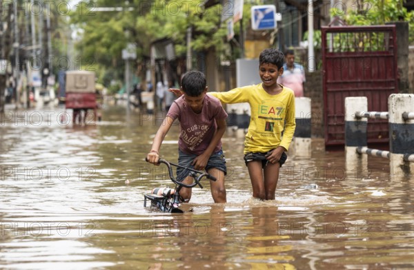 Children wade through a flooded street after heavy rains in Guwahati, India on April 28, 2025
