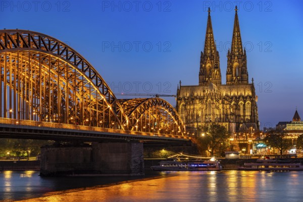 Cologne Cathedral, has been shining in new light since Easter 2025, the old metal halide lamps have been replaced by over 700 modern LED lamps, reducing energy consumption by around four fifths, significantly improving the quality of light and greatly reducing light emissions, 12 KM of new cables were laid for this, Hohenzollern Bridge, railway bridge over the Rhine, North Rhine-Westphalia, Germany, Europe