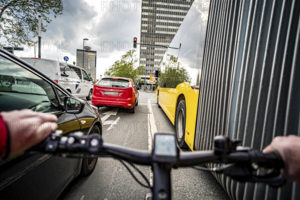 Cycling in the city, city centre road, no cycle path, bus stop, two-lane traffic in both directions, cyclists' perspective, Essen, North Rhine-Westphalia, Germany, Europe