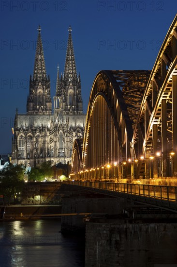 Cologne Cathedral, has been shining in new light since Easter 2025, the old metal halide lamps have been replaced by over 700 modern LED lamps, reducing energy consumption by around four fifths, significantly improving the quality of light and greatly reducing light emissions, 12 KM of new cables were laid for this, Hohenzollern Bridge, railway bridge over the Rhine, North Rhine-Westphalia, Germany, Europe