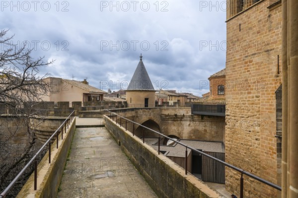 Stone walkway and watchtower rising above the rooftops of olite, offering breathtaking views of the royal palace and surrounding landscape