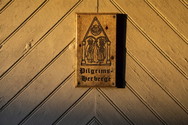 Pilgrims and Olav the Saint or Olav II Haraldsson with axe, Pilgrims Hostel lettering, wooden plaque on door with engraving, on a wooden door, Pilgrims Hostel Arteid Vestre Gård, Norway, Europe
