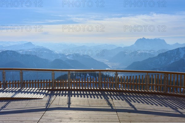 Wooden platform with a view of snow-covered mountains under a blue sky, Steinplatte, Waidring, Tyrol, Austria, Europe