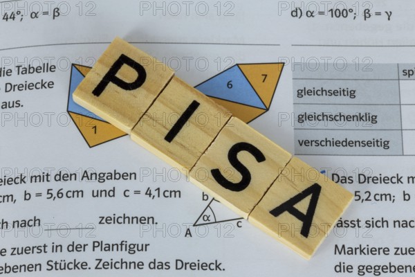 PISA study Symbolic image: Maths problems in the textbook of a comprehensive school pupil show the word PISASTUDIE on a letter cube