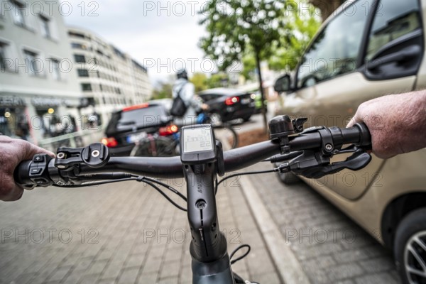 Cycling in the city, inner-city street, cycle lane, bicycles have priority, two-lane traffic with parked cars on both sides, cyclists' perspective, Essen, North Rhine-Westphalia, Germany, Europe