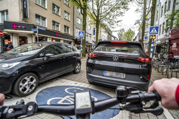 Cycling in the city, inner-city street, cycle lane, bicycles have priority, two-lane traffic with parked cars on both sides, cyclists' perspective, Essen, North Rhine-Westphalia, Germany, Europe