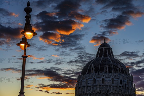 Baptistery chapel under an illuminated street lamp at sunset, Pisa Tuscany, Italy, Europe