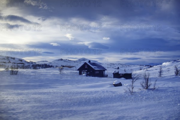 Snowy landscape with a house and mountains on the horizon under a calm sky, Norway, Europe