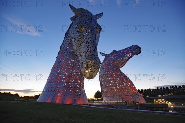 Large illuminated horse sculptures at dusk against the evening sky, legends and myths, Kelpies, Scotland, Great Britain