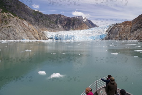 Small boat approaching the front of a glacier calving into the sea, Tracy Arm Fiord, Tongass National Forest, Juneau, Inside Passage, Alaska, USA, North America