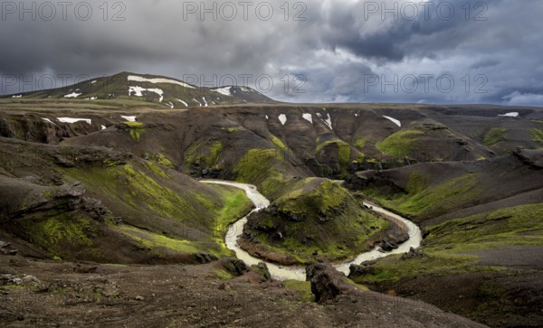 River bend, foot Asgardsa, volcanic landscape with black rocks and green moss, dramatic cloudy sky, Kerlingarfjöll, Icelandic highlands, Iceland, Europe