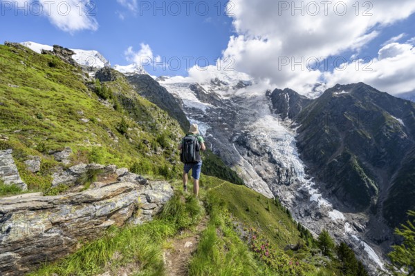 Mountaineer in front of impressive mountain landscape with glacier, view of glacier Glacier de Taconnaz, hike La Jonction, Chamonix, Haute-Savoie, France, Europe