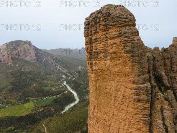 View of a huge rock, a valley with a river below and an impressive natural backdrop, aerial view, Las Peñas de Riglos, As Penyas de Riglos, Mallos de Riglos rock formation, Huesca, Aragon, Spain, Europe