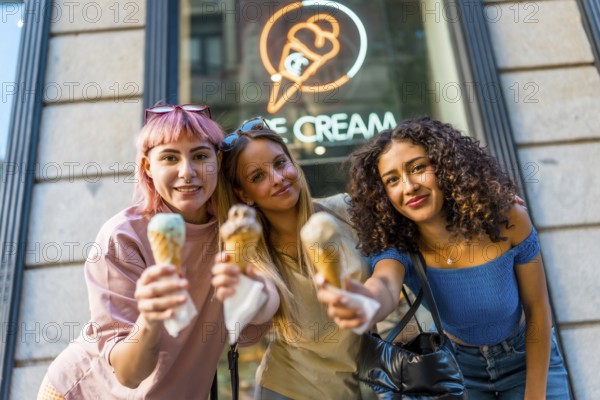 Three beauty different woman holding delicious ice creams outside the store