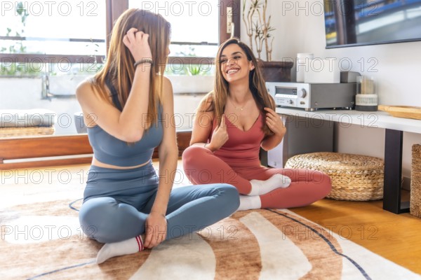 Two friends enjoying an online class, practicing yoga and meditation in a cozy living room setting, fostering relaxation and mindfulness