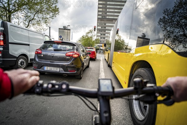 Cycling in the city, city centre road, no cycle path, bus stop, two-lane traffic in both directions, cyclists' perspective, Essen, North Rhine-Westphalia, Germany, Europe