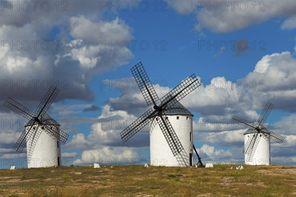 Three windmills in front of a dramatic sky with imposing clouds, Campo de Criptana, Ciudad Real province, Castilla-La Mancha, Don Quixote Route, Spain, Europe