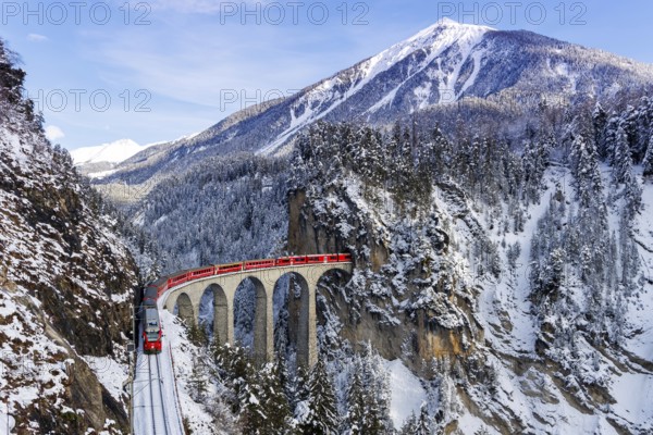 Rhaetian Railway train at the famous Landwasser Viaduct on the Albula railway Stadler Rail passenger train in the Alps in Filisur, Switzerland, Europe