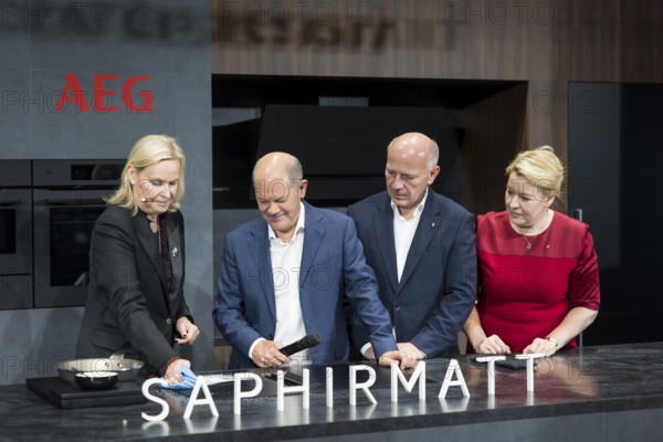 Olaf Scholz (Chancellor of the Federal Republic of Germany, SPD), Kai Wegner (Governing Mayor of Berlin, CDU) and Franziska Giffey (Senator for Economics, Energy and Public Enterprises and Mayor of Berlin, SPD) are shown an AEG hob during a press tour of the IFA (Internationale Funkausstellung) exhibition at the exhibition grounds, Berlin, 06/09/2024