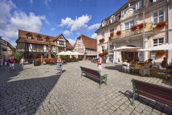 Market square with benches, historic buildings and half-timbered houses under a blue sky with cumulus clouds in Michelstadt, Odenwald, Odenwaldkreis, Hesse, Germany, Europe