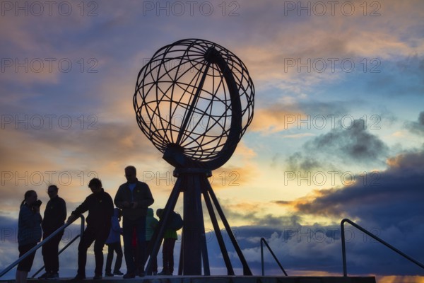 Tourists in front of the steel globe at the North Cape in the evening light, Nordkapp, Finnmark, Norway, Europe
