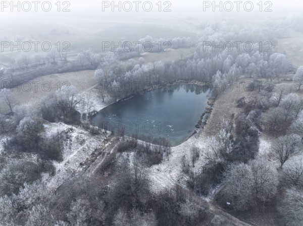 Aerial view of a small lake surrounded by winter hoar frost in a peaceful landscape, Gechingen, Black Forest, Germany, Europe