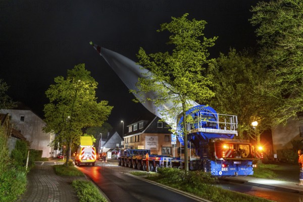 Transport of a 68 metre long, 22 tonne blade of a wind turbine, here in Breckerfeld-Waldbauer, with a self-propelled Blade-Lifter vehicle, over a 40 km long route, over 2 nights, in the Bergisches Land, through towns, villages, on country roads, narrow through roads, to the construction site of the wind turbine near Hagen, North Rhine-Westphalia, Germany, Europe