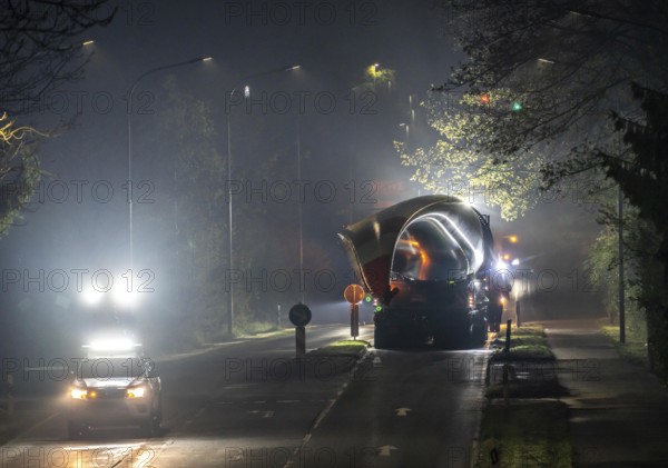 Transport of a 68 metre long, 22 tonne blade of a wind turbine, here in Breckerfeld, with a self-propelled Blade-Lifter vehicle, over a 40 km long route, over 2 nights, in the Bergisches Land, through towns, villages, over country roads, narrow through roads, to the construction site of the wind turbine near Hagen, North Rhine-Westphalia, Germany, Europe