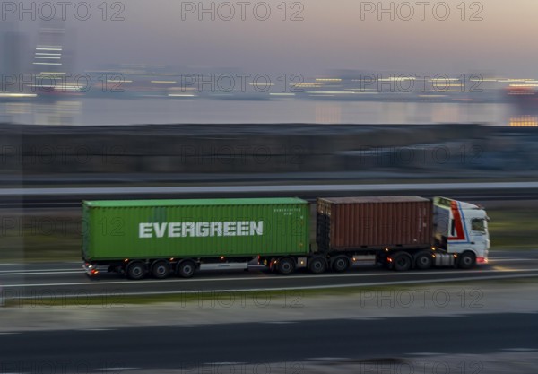Lorry on the road from Euromax Terminal Rotterdam, ENECO wind farm on the dike around the port of Maasvlakte 2, 22 wind turbines with a capacity of 116 megawatts, sunset, Rotterdam, Netherlands Evergreen Container