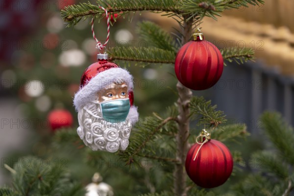 Symbolic image of Christmas in the Corona crisis, Father Christmas figure, Christmas tree decoration, with mouth and nose mask, everyday mask