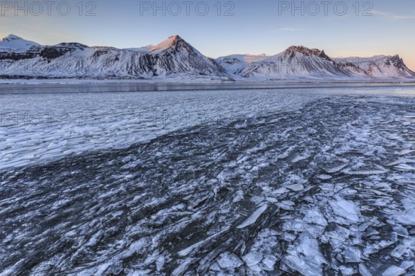 Ice floes on a lake in front of snowy mountains, ice, sun, evening light, snow, winter, Snaefellsnes, Vesturland, Iceland, Europe