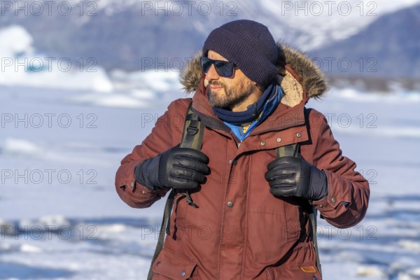 Portrait of a hiker walking on the frozen lake of Jokulsarlon glacier in Iceland
