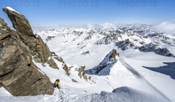 Mountaineer with ice axe and crampons, ascent through steep snowfield to Piz Kesch or Piz d'Es-cha in winter, view of mountain panorama with Vadret da Porchabella glacier, Albula Alps, Rhaetian Alps, Grisons, Eastern Switzerland, Switzerland, Europe