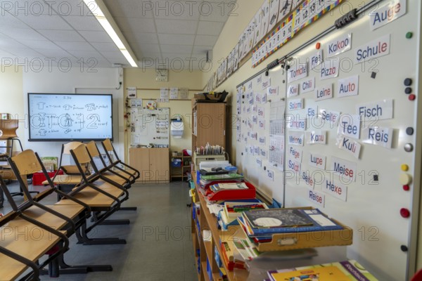 Classroom of a fourth grade, after school, the building is older but in good condition, modern teaching materials, interactive, digital whiteboard