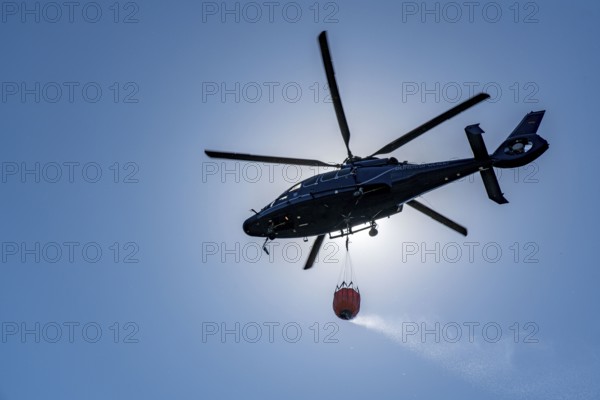 Forest fire in the German-Dutch border region near Niederkrüchten-Elmpt, in a nature reserve, deployment of fire-fighting helicopters, Eurocopter EC 155, Federal Police with extinguishing water tank, Bambi Bucket