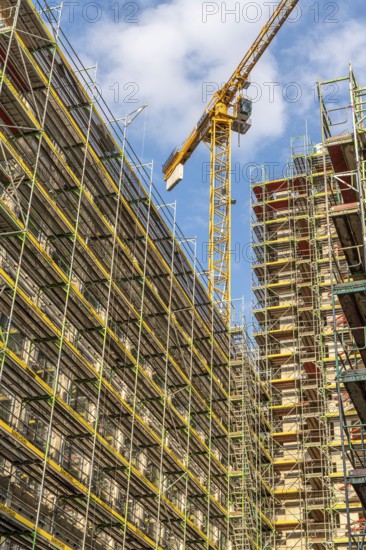 Construction site of a large building project on Huyssenallee in Essen, Huyssen Quartier, residential tower block with 19 floors, an office building with 5 floors, scaffolded new building, Essen, North Rhine-Westphalia, Germany, Europe