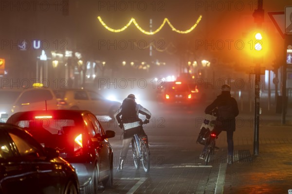 Cyclist, darkness, inner city traffic, Rüttenscheider Straße, bicycle lane, fog, autumn, winter, evening traffic, North Rhine-Westphalia, Germany, Europe