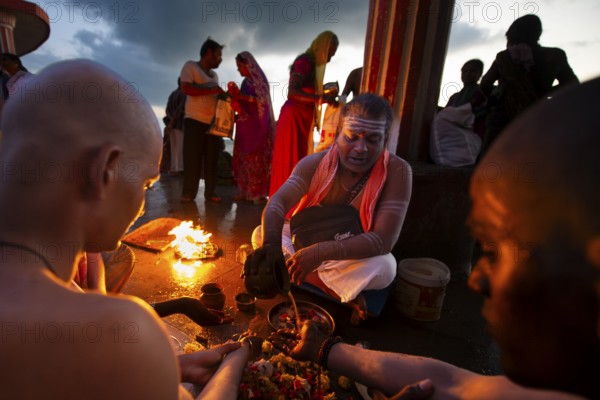 Hindu priest with pilgrims at the fire ritual at Ghat Agni Theertham, Rameswaram, Pamban Island, Tamil Nadu, India, Asia