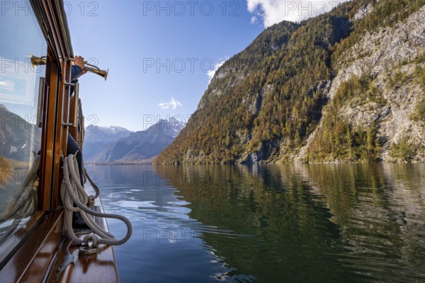 A trumpet is played on the echo wall of a tourist boat, Königssee, autumnal mountain landscape reflected in the lake, Berchtesgaden National Park, Berchtesgadener Land, Upper Bavaria, Bavaria, Germany, Europe